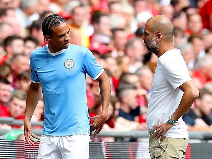 Manchesters Leroy Sane (l.) spricht nach seiner Auswechslung mit Trainer Pep Guardiola. Foto: Martin Rickett/PA Wire/Archivbild