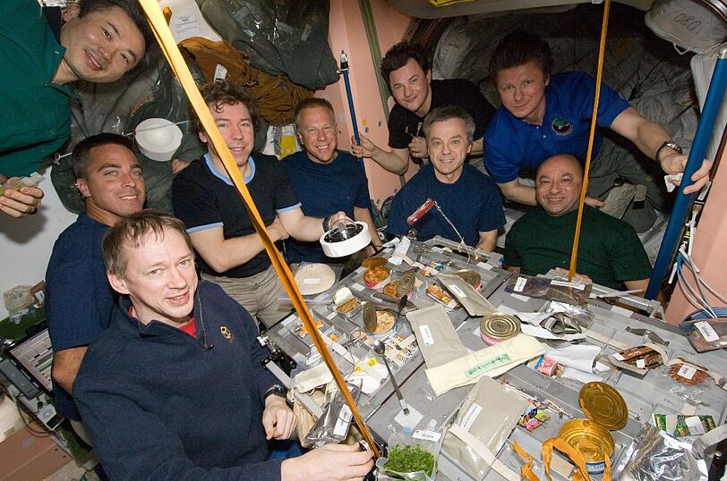 Auf diesem Bild sind neun von 13 Besatzungsmitgliedern der ISS abgebildet, die gerade ein kleines Fest feiern.