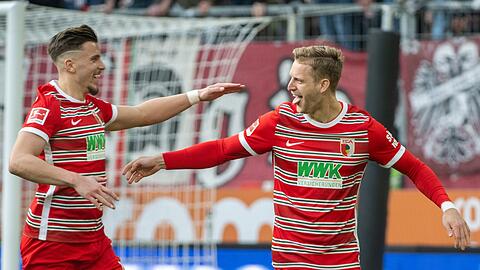 Augsburgs Torschütze Arne Maier (r) und Emirdan Demirovic jubeln über den Treffer zum 2:1.