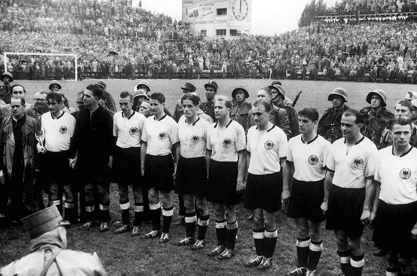 "Das Wunder von Bern". Die DFB-Elf nimmt Aufstellung zur Siegerehrung - natürlich ganz klassisch und schlicht in weißen Hemden und schwarzen Hosen.