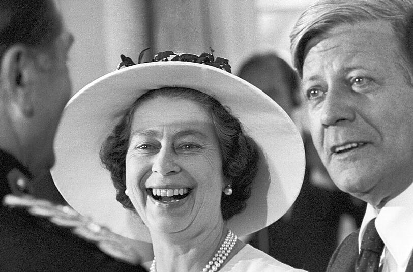 Mai 1978: In bester Laune unterhält sich Elizabeth II. auf dem Empfang des Senats im Schloss Charlottenburg in Berlin mit Bundeskanzler Helmut Schmidt (r) und mit dem britischen Stadtkommandanten Robert F. Richardson.