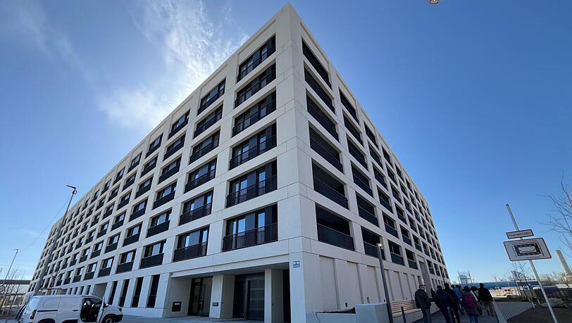 So sieht das erste fertige Wohnhaus von außen aus. Ein privates Unternehmen hat es errichtet. Dieses wollte eigentlich noch viel mehr Wohnungen bauen. Dann sind die Baukosten explodiert.