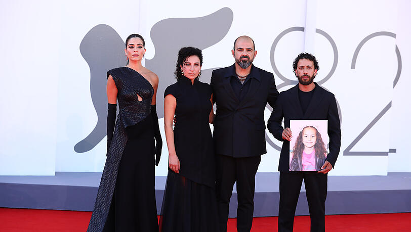 Saja Kilani (von links), Clara Khoury, der israelische Schauspieler Amel Hlehel und Motaz Malhees stehen mit einem Foto des palästinensischen Mädchens Hind Rajab auf dem roten Teppich für den Film „The Voice of Hind Rajab“ während der 82. Ausgabe der Filmfestspiele von Venedig. Saja Kilani (von links), Clara Khoury, der israelische Schauspieler Amel Hlehel und Motaz Malhees stehen mit einem Foto des palästinensischen Mädchens Hind Rajab auf dem roten Teppich für den Film „The Voice of Hind Rajab“ während der 82. Ausgabe der Filmfestspiele von Venedig.