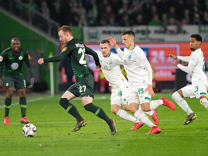 Der ballführende Wolfsburger Maximilian Arnold (l-r) wird von den Brüdern Johannes und Maximilian Eggestein bedrängt.