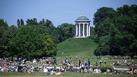 Zahlreiche Menschen genießen in München das schöne Wetter im Englischen Garten.