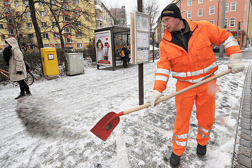 Nicht nur mit großen Maschinen, sondern auch mit Schaufel und Muskelkraft rücken Männer vom Räumdienst dem Schnee zu Leibe.