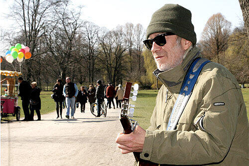 Straßenmusiker &bdquo;DD Beck&ldquo; (57) verdient sich seit über zehn Jahren im Englischen Garten mit seiner Gitarre ein paar Euro dazu.