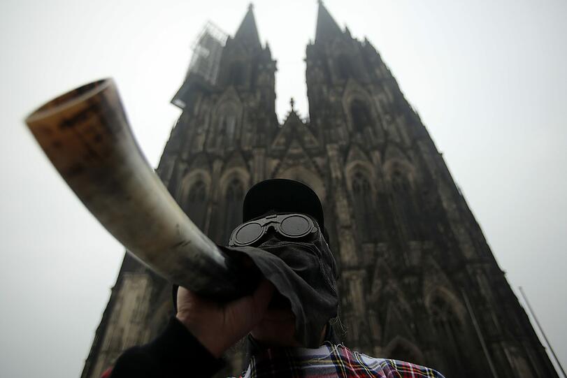 Multitasking? Dieser Mann beobachtet die Sonnenfinsternis in Köln, während er auf dem Horn ein Liedchen anstimmt. Wär ja auch sonst zu öde!
