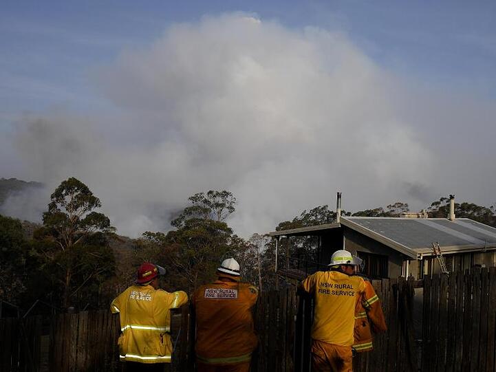 Feuerwehrmänner beobachten aufsteigende Rauchwolken eines Buschfeuers bei Penrose südlich von Sydney.