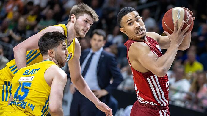 Albas Tamir Blatt (l-r) und Ben Lammers kämpfen gegen Jason George von Bayern München um den Ball.