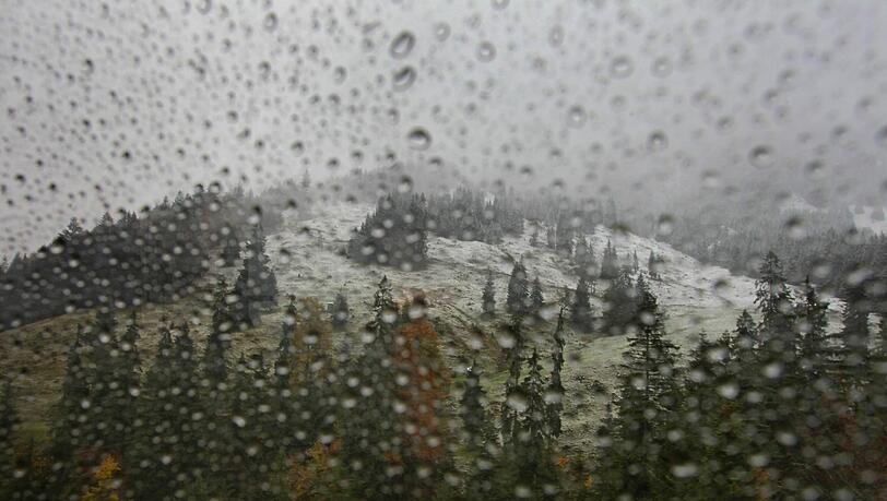 Hinter der regennassen Fensterscheibe einer Gondel der Nebelhornbahn liegt am 15.10.2012 die teilweise mit Schnee bedeckte herbstliche Landschaft bei Oberstdorf (Bayern). Hinter der regennassen Fensterscheibe einer Gondel der Nebelhornbahn liegt am 15.10.2012 die teilweise mit Schnee bedeckte herbstliche Landschaft bei Oberstdorf (Bayern).