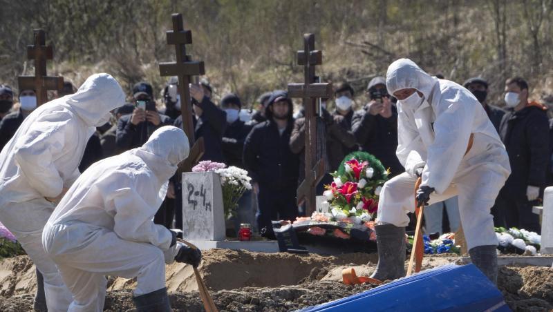 Totengräber in Schutzkleidung lassen auf einem Friedhof im russischen Kolpino den Sarg eines Covid-19-Opfers in ein Grab hinab. Totengräber in Schutzkleidung lassen auf einem Friedhof im russischen Kolpino den Sarg eines Covid-19-Opfers in ein Grab hinab.