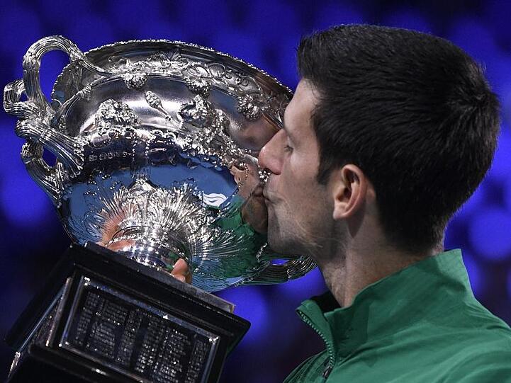 Novak Djokovic küsst nach dem hart erkämpften Finalsieg gegen Thiem den Siegerpokal.
