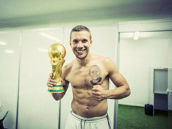 Lukas Podolski mit Pokal und Tattoo