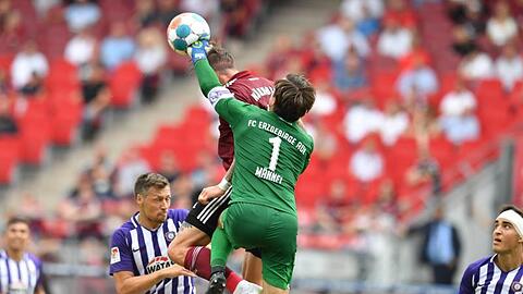 Torwart Martin Männel (r) von Aue faustet den Ball neben Manuel Schäffler von Nürnberg.