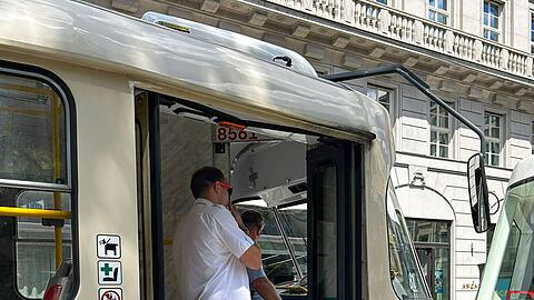 Straßenbahnfahrer unterhalten sich in einer stehenden Straßenbahn miteinander.
