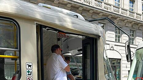 Straßenbahnfahrer unterhalten sich in einer stehenden Straßenbahn miteinander.