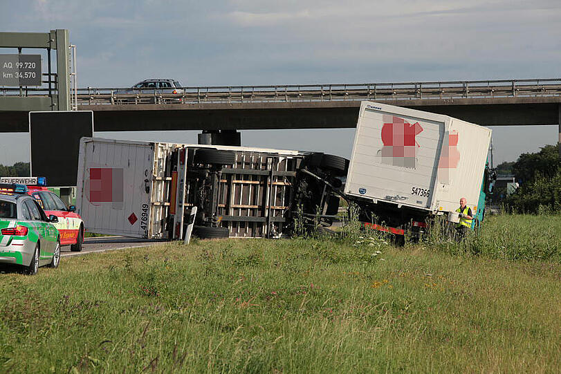 Vermutlich weil er zu schnell auf die Autobahn fährt, kommt ein Laster in der Kurve von der Fahrbahn ab und fährt in die Leitplanke. Sein Hänger kippt um.