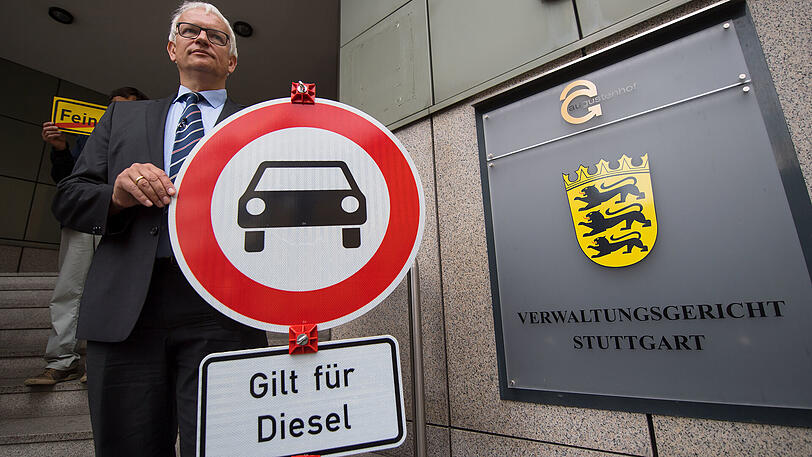 Jürgen Resch, der Bundesgeschäftsführer der Deutschen Umwelthilfe, hält vor der Urteilsverkündung ein Verbotsschild mit der Aufschrift "Gilt für Diesel" in die Kamera.