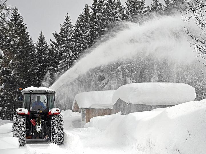 Ein Schneepflug räumt eine Straße in Ramsau am Dachstein. Österreich versinkt im Schnee.