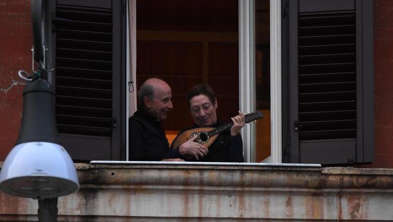 Ein Mann und eine Frau mit einem Instrument an einem geöffneten Fenster in Rom. Ein Mann und eine Frau mit einem Instrument an einem geöffneten Fenster in Rom.