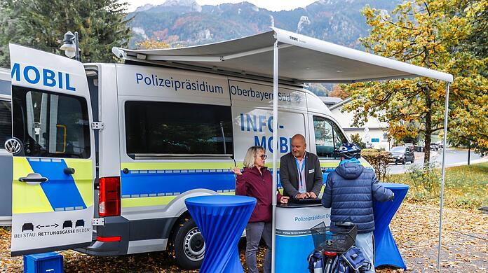 Kommissarin Irene Stephl (l) und Kommissar Karl-Heinz Busch (M) sprechen am Infomobil mit einem Anwohner.
