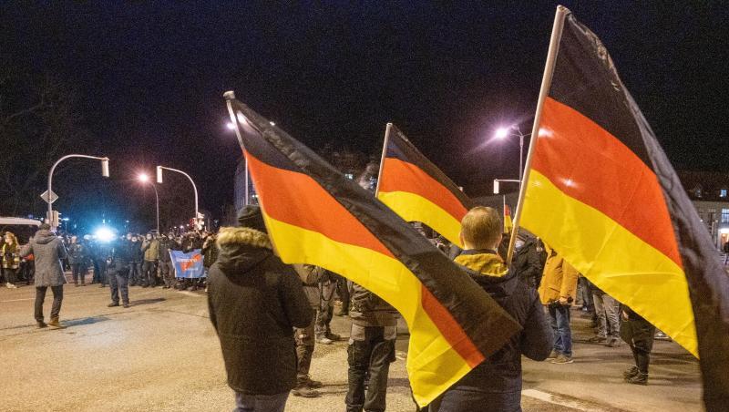 Teilnehmer einer Demonstration gegen die Corona-Maßnahmen tragen Deutschland-Fahnen.
