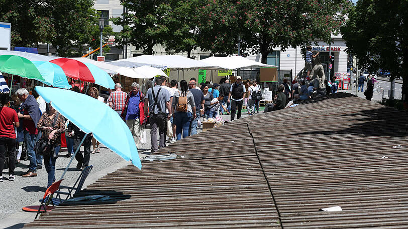Einer der Märkte am Orleansplatz &ndash; und rechts die Bretter auf dem Brunnen, der nie plätschert.