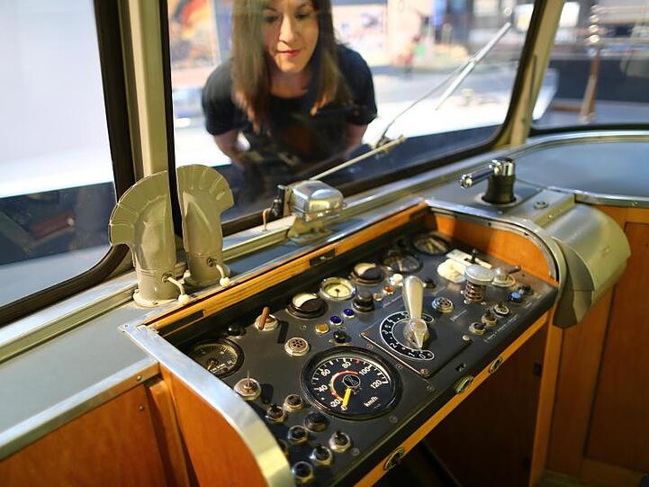 Eine Frau betrachtet den Führerstand eines Schienenbusses aus den 50er Jahren im DB Museum. Foto: Daniel Karmann/Archiv