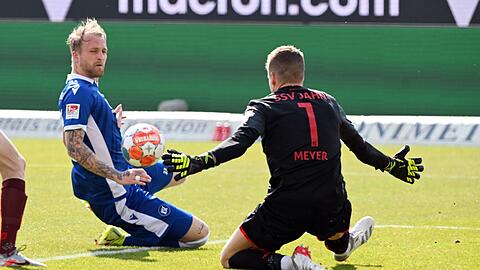 Regensburgs Torwart Alexander Meyer (r) wehrt einen Ball des Karlsruhers Philipp Hofmann ab.