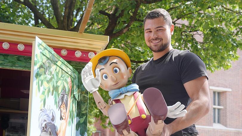 Kevin Kraus beim Aufbau: Zu seinem Kinderkarussell geh&ouml;rt auch eine Pinocchio-Figur.
