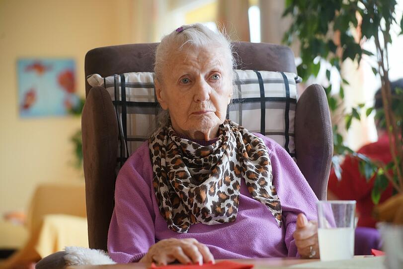 Die 86-jährige Gisela Petrus schaut mit großen, traurigen Augen in den Raum. Ihre Mimik ist wie eingefroren.