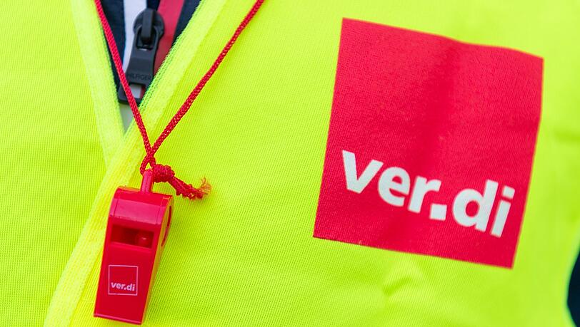 Ein Streikender trägt eine Warnweste mit dem Verdi-Logo (Symbolbild).