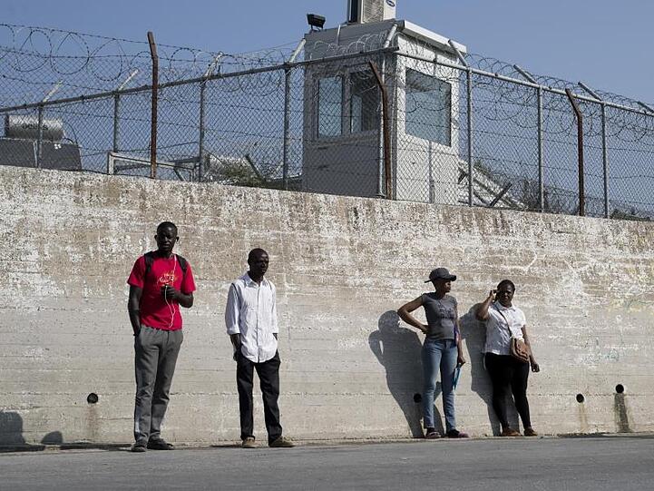 Migranten an einer Mauer des Flüchtlingslagers Moria auf der Insel Lesbos.