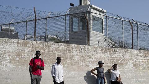 Migranten an einer Mauer des Flüchtlingslagers Moria auf der Insel Lesbos.