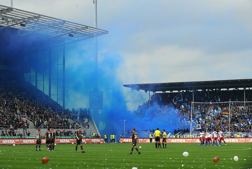 Auch in Hamburg kam es vergangenes Jahr rund um das Stadtderby zwischen dem FC St. Pauli und dem Hamburger SV zu Fan-Ausschreitungen. Hier zünden HSV-Fans während der Partie bengalische Feuer am Millerntor.