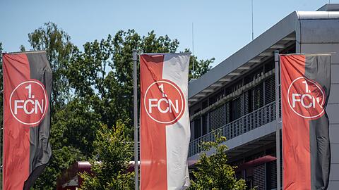 Fahnen mit dem FCN-Logo wehen vor dem Vereinsgebäude.