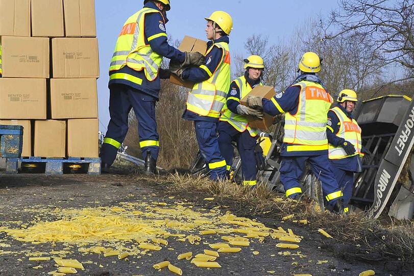 Hilfskräfte des Technischen Hilfswerks entluden den umgekippten Lkw. Die ein oder andere Nudel ging dabei zu Bruch.