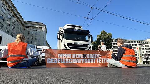 Aktivisten der Gruppe "Letzte Generation" blockieren eine Straße in Berlin.