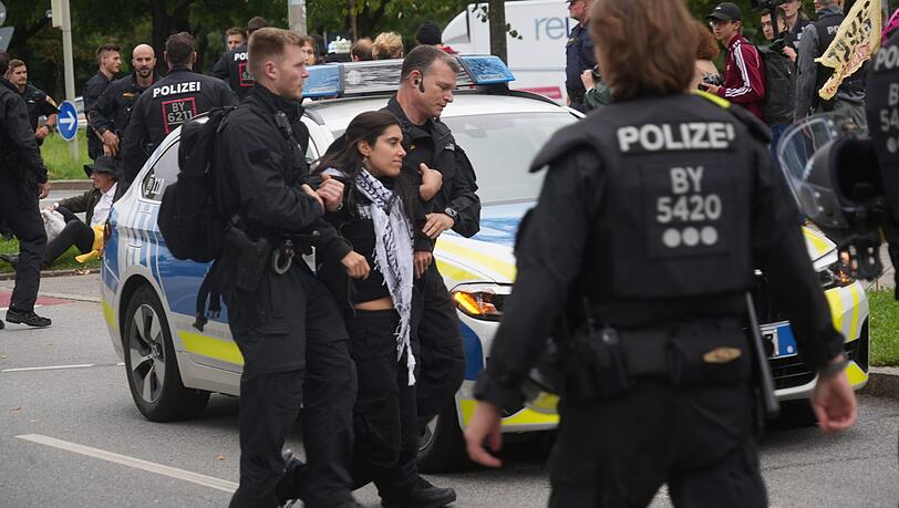 Protest gegen die IAA vor der BMW-Welt. Polizisten tragen eine Person weg, die versucht hat, die Lerchenauer Straße zu blockieren.