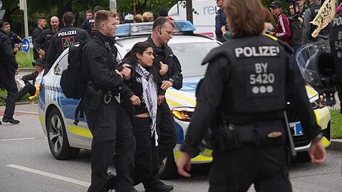 Protest gegen die IAA vor der BMW-Welt. Polizisten tragen eine Person weg, die versucht hat, die Lerchenauer Straße zu blockieren.
