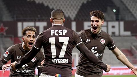 Daniel-Kofi Kyereh (M) feiert seinen Treffer zum 1:0 für den FC St. Pauli gegen den HSV mit Rodrigo Zalazar und Luca Zander (r).