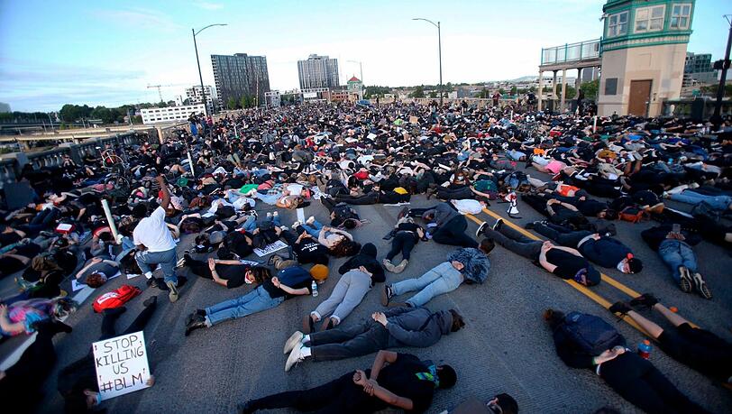 Portland: Die Demonstranten liegen bäuchlings mit den Händen auf dem Rücken neun Minuten lang auf dem Boden und symbolisieren damit die Zeit, die ein Polizist auf dem Hals von George Floyd kniete. Portland: Die Demonstranten liegen bäuchlings mit den Händen auf dem Rücken neun Minuten lang auf dem Boden und symbolisieren damit die Zeit, die ein Polizist auf dem Hals von George Floyd kniete.