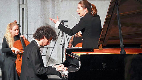 Dirigentin Anna Handler und Can Cakmur am Flügel mit dem Enigma Classica Ensemble im Utopia (Reithalle).