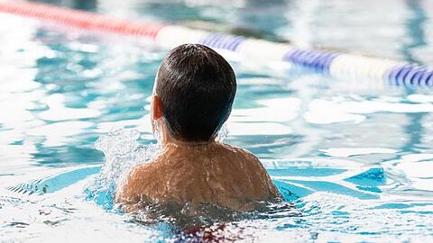 Ein Junge schwimmt in einem Schwimmnad.