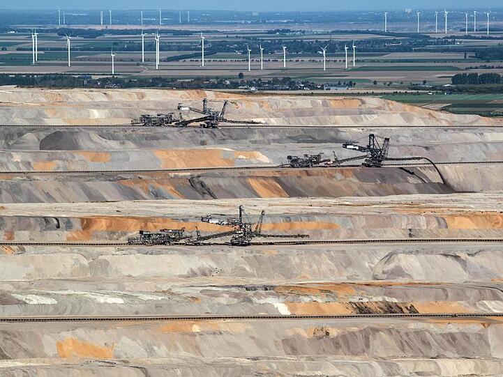Im Tagebau Hambach arbeiten Bergbaumaschinen. Der angrenzende Hambacher Forst gilt als Symbol des Widerstands gegen die Kohle.