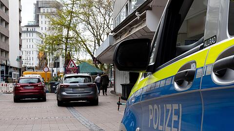 Fahrzeuge der Polizei stehen vor dem Wohnhaus des Tatverdächtigen im Fall des Messerangriffs in einem Duisburger Fitnessstudio.