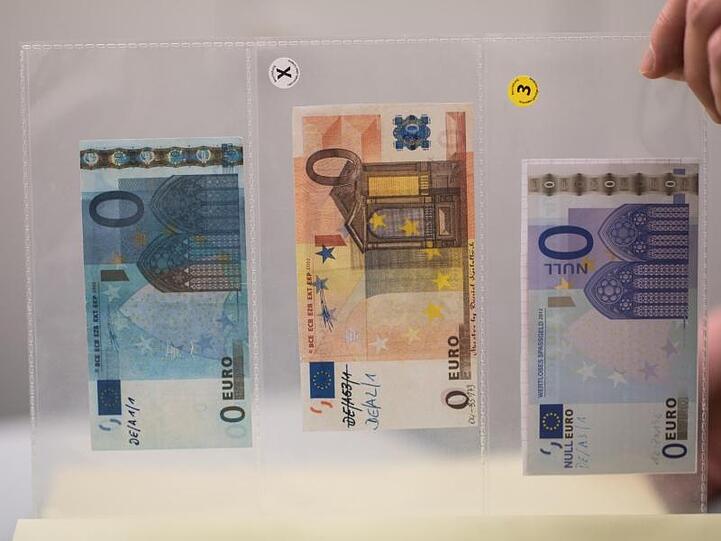 In einer Klarsichtfolie sind drei sichergestellte 0 Euro Fantasie-Banknoten zu sehen. Foto: Andreas Arnold/Archiv