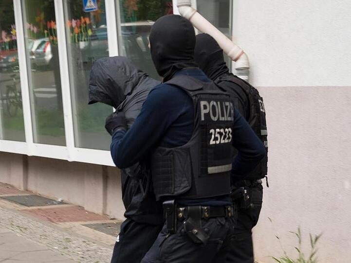 Polizeibeamte führen dreieinhalb Monate nach dem spektakulären Diebstahl einer 100-Kilo-Goldmünze aus dem Berliner Bode-Museum einen Mann ab.