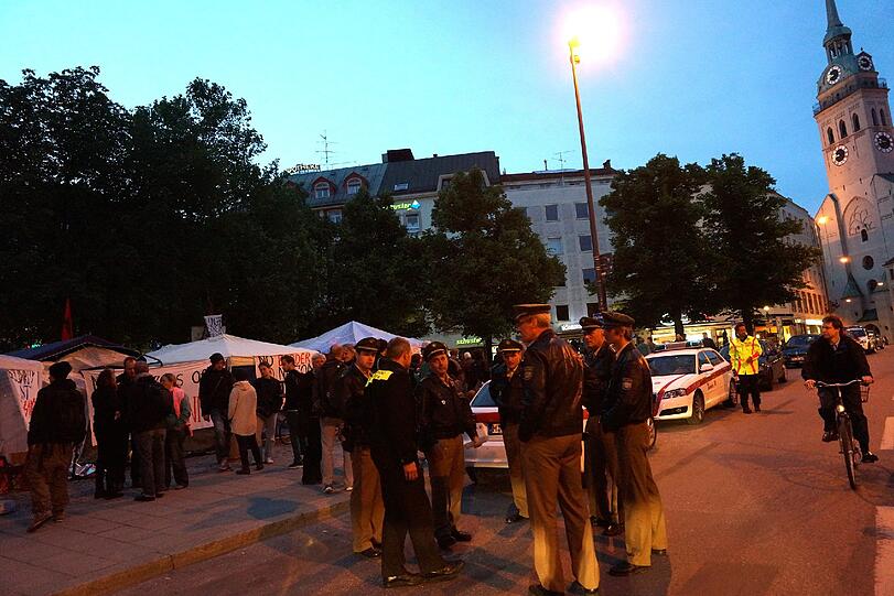 Polizisten und Notärzte stehen um das Camp am Rindermarkt. Seit Dienstag trinken die Protestierenden nichts mehr.